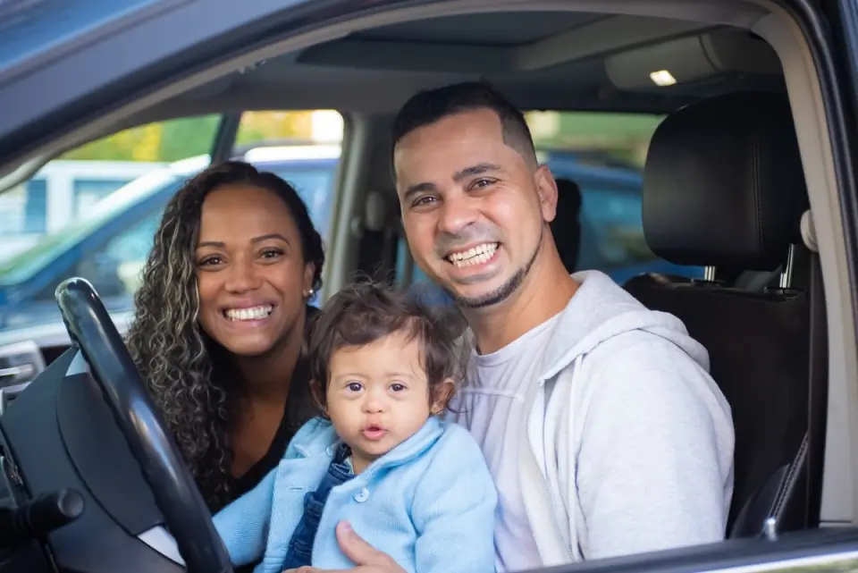 Família sorrindo dentro do carro